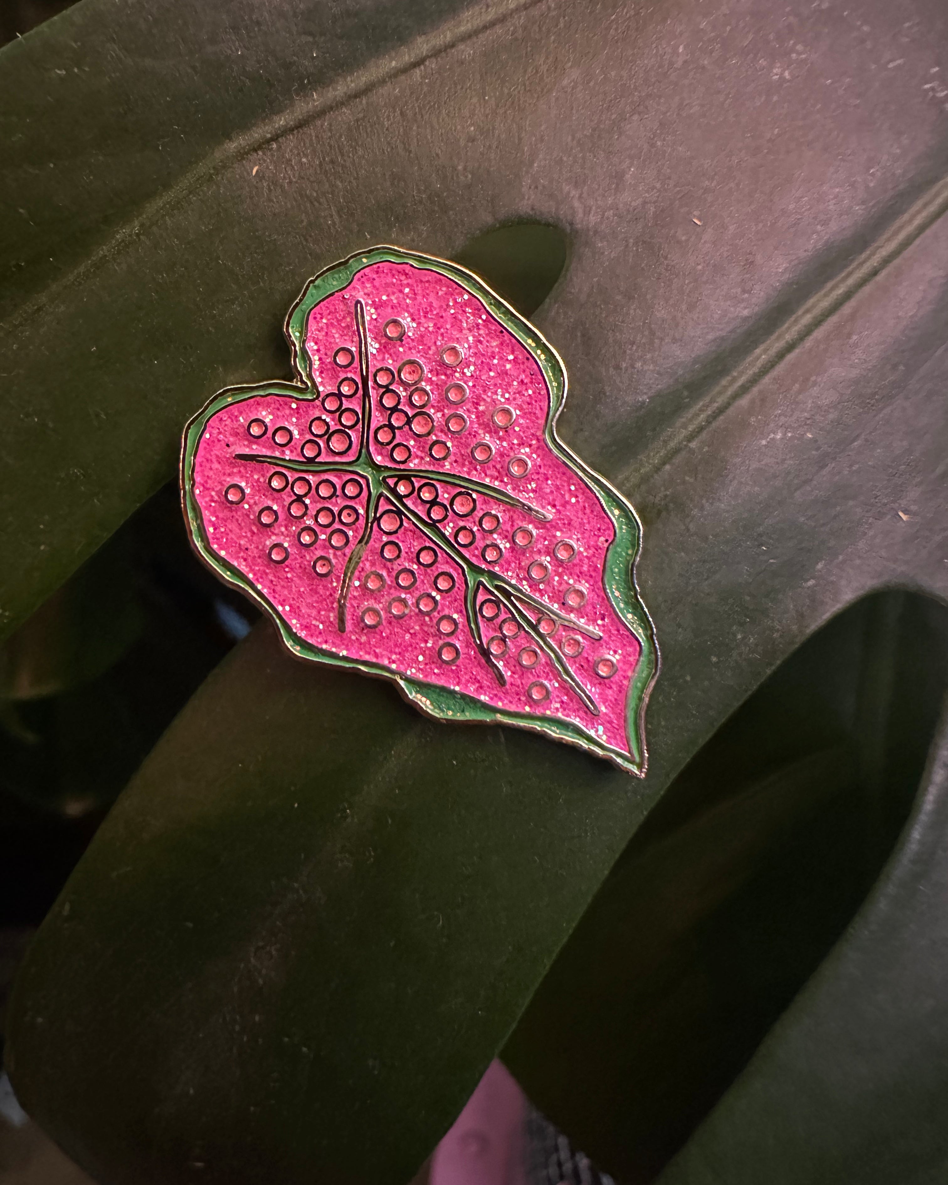 Pink leaf-shaped object with a textured surface on a dark background