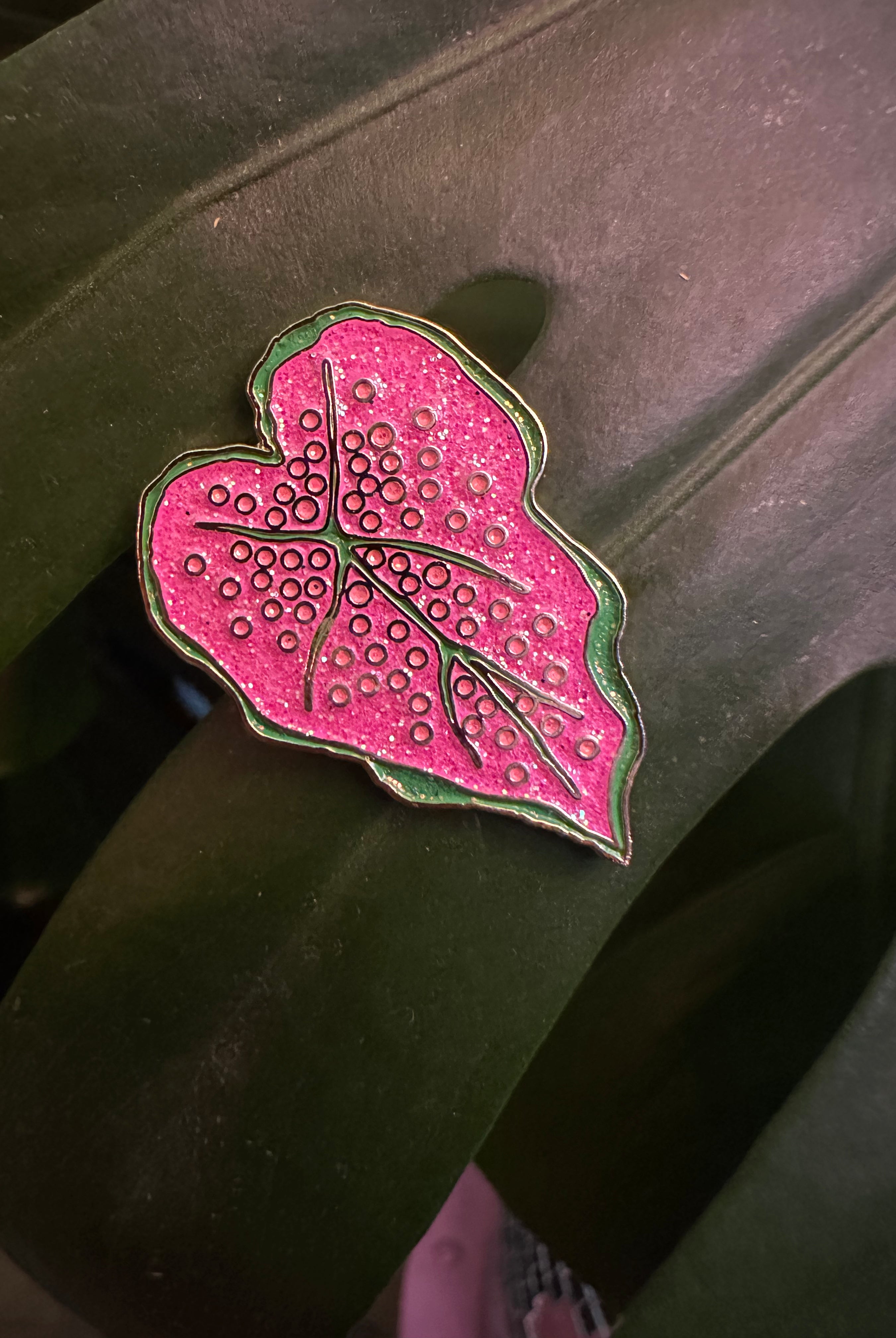 Pink leaf-shaped object with a textured surface on a dark background