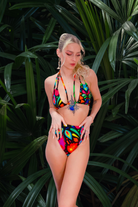 Model wearing the Lycra Bikini from L•O•M in Femina Magicae Black and Rainbow print