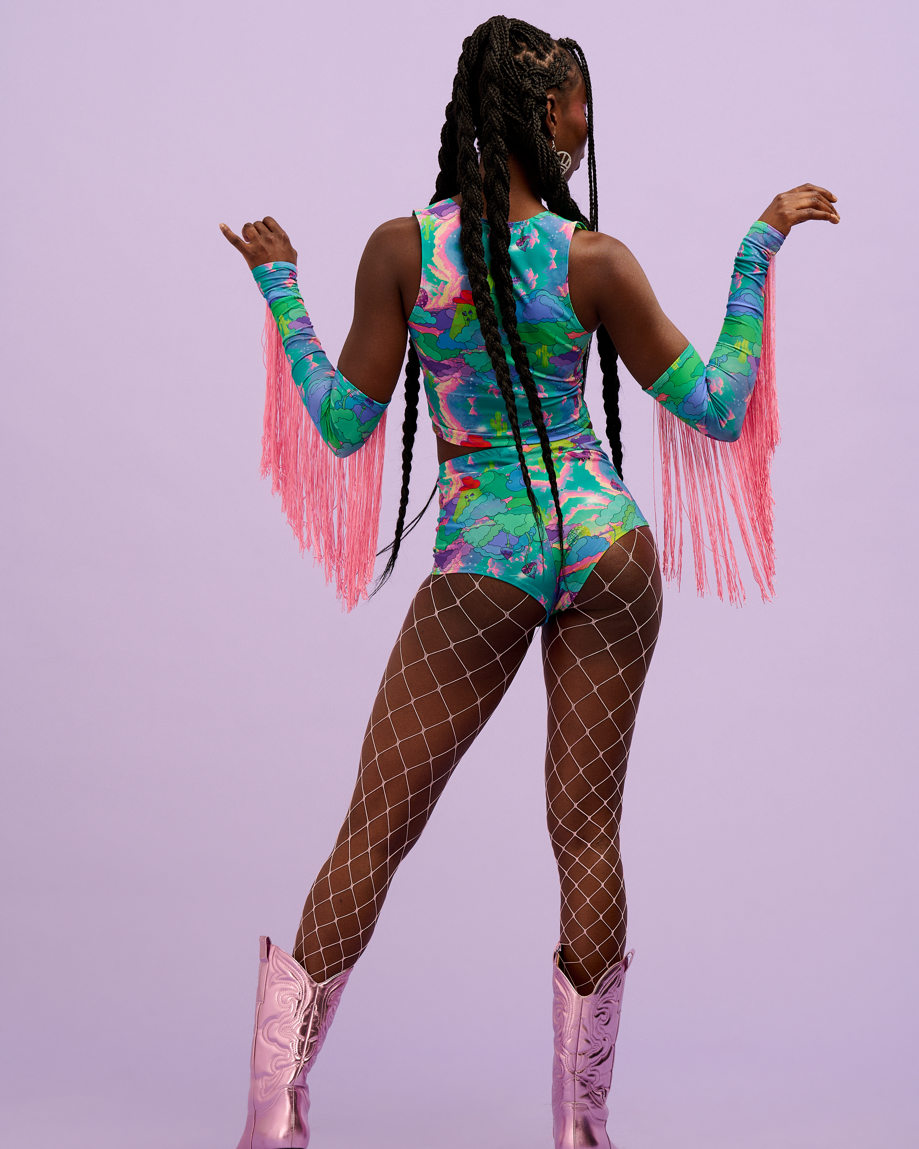 Model on photoshoot background wearing Intergalactic Rodeo lycra outfit including Hot Pants, matching top and sleeves.