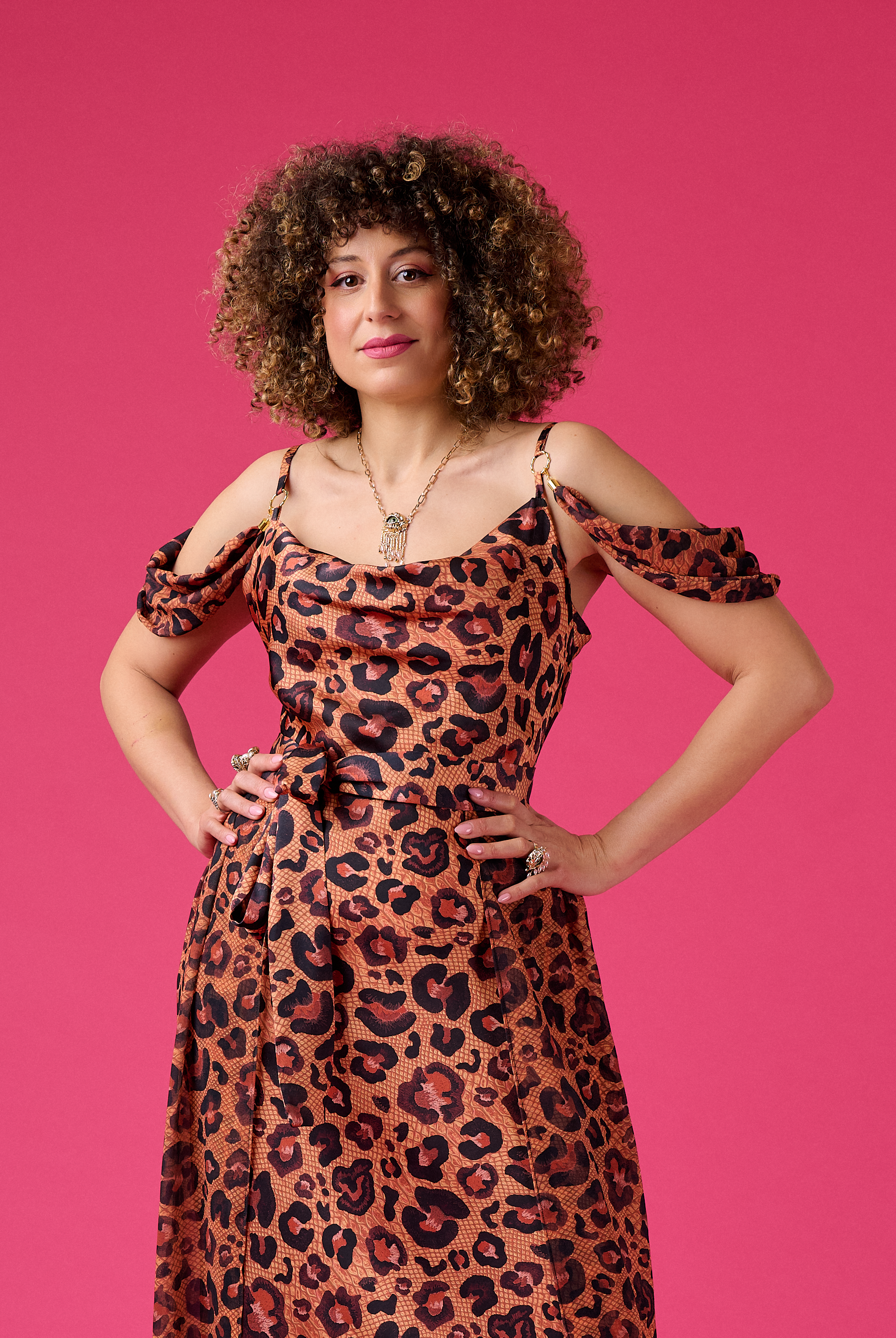 Woman wearing a leopard print dress against a pink background