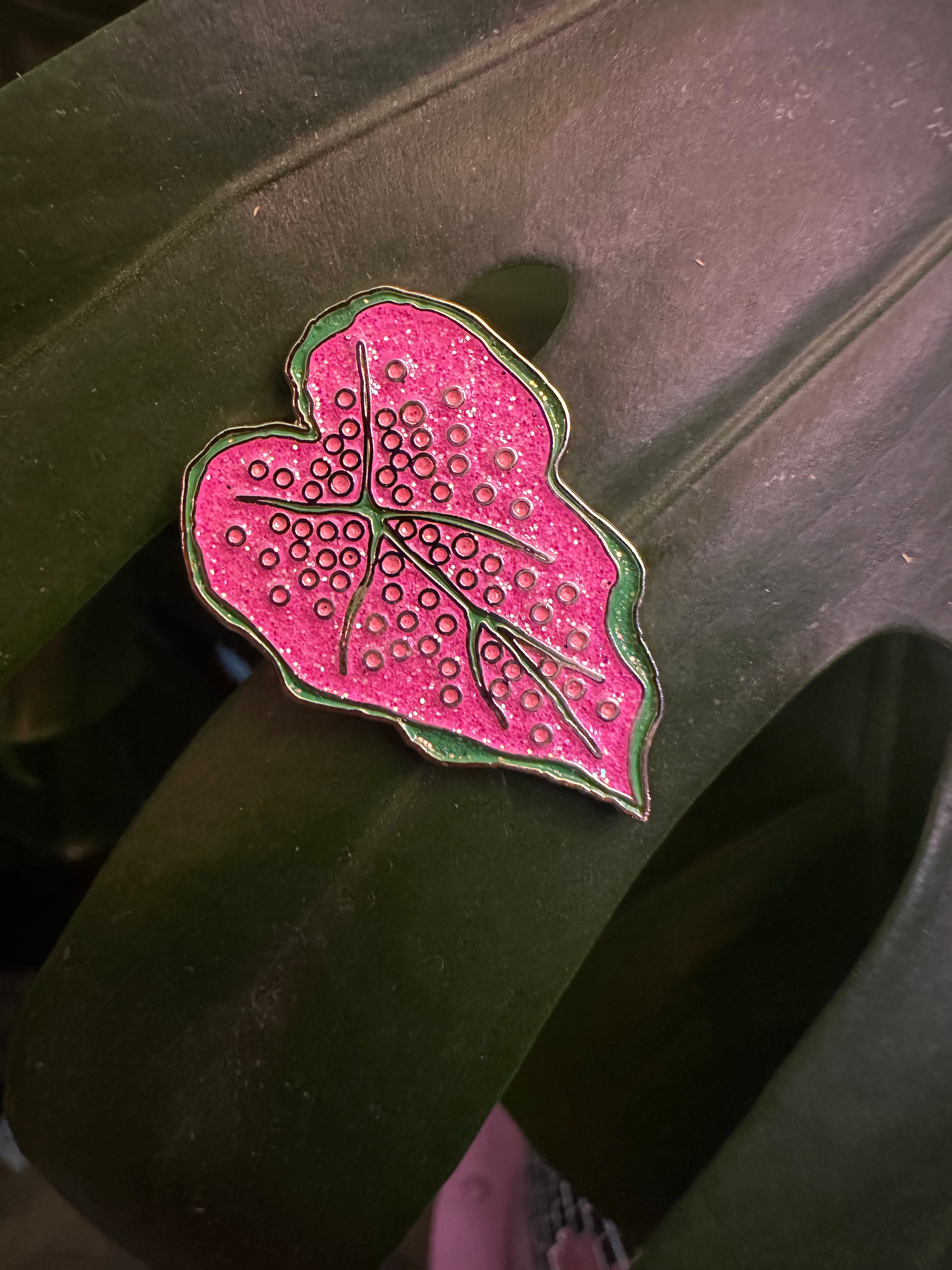 Pink leaf-shaped object with a textured surface on a dark background
