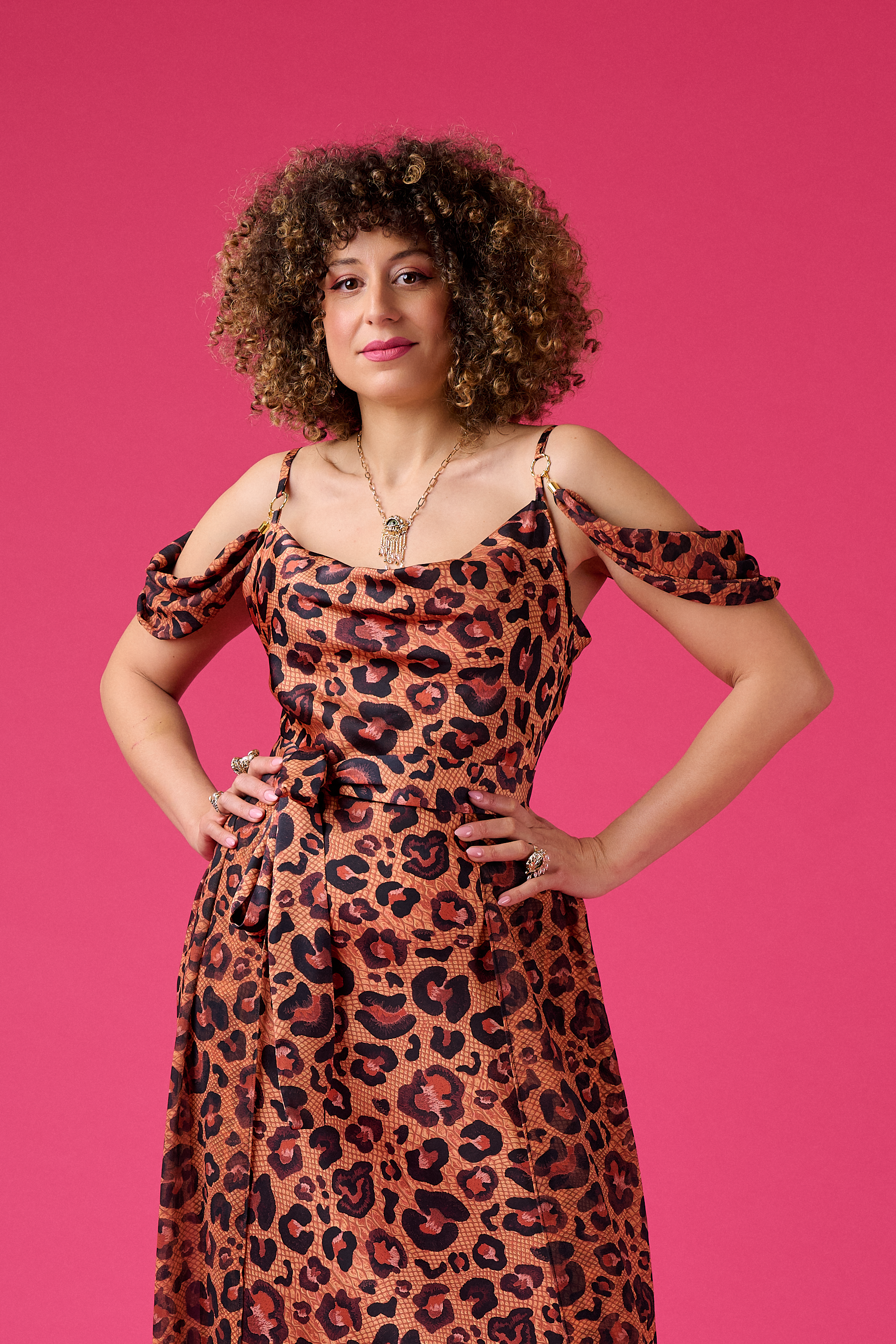 Woman wearing a leopard print dress against a pink background