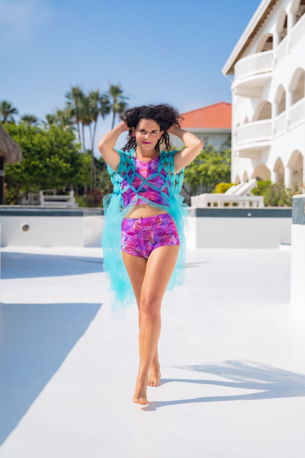 Model wearing matching two piece lycra hot pants and sleeveless crop top in pink forest of dreams print